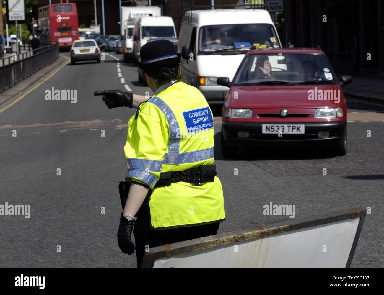 Unterstützung Gemeindepolizisten umleiten Verkehr nach einem Wasserrohrbruch entlang der Beech Avenue in Brentford, in West-London. Stockfoto