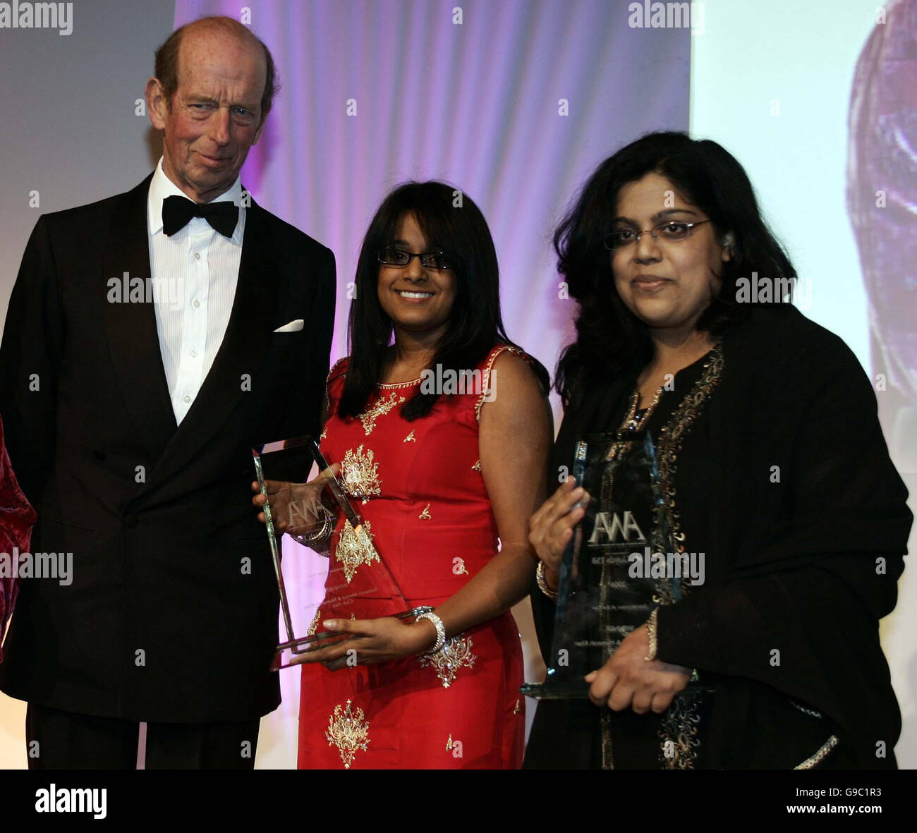 S.H. The Duke of Kent überreicht Sumerah Ahmad, 32, (Mitte) und Humerah Khan, 34, Mitbegründer und Direktoren des Clubs Asia Radio, Essex, den Entrepreneur of the Year Award bei den Asian Women of Achievement Awards in London. Stockfoto