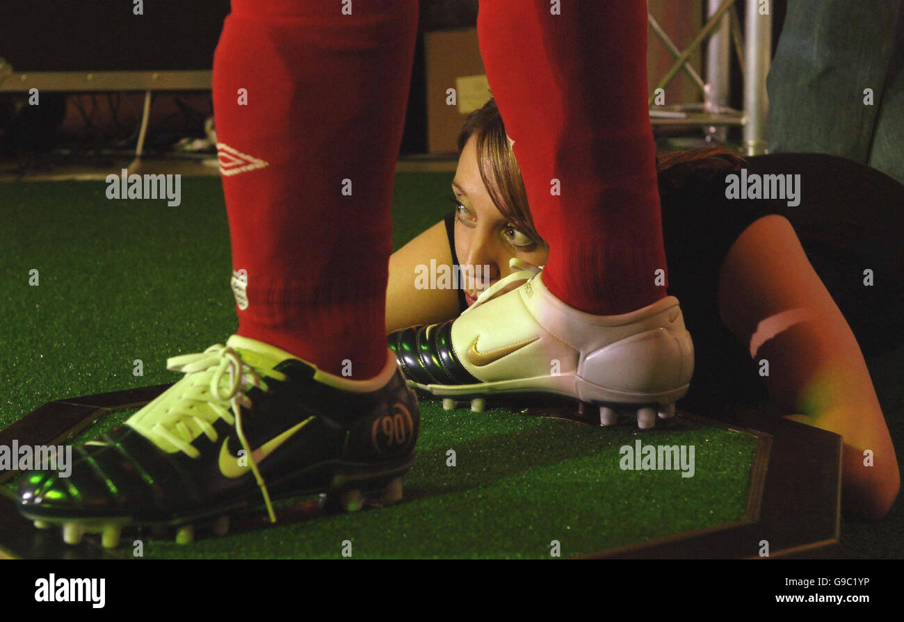 Der rechte Fuß der neuen Wachsfigur des englischen Fußballers Wayne Rooney wird von Suzy Clarke, einem Tussauds-Mitarbeiter, während der Enthüllung im Madame Tussauds im Zentrum von London geküsst. Stockfoto