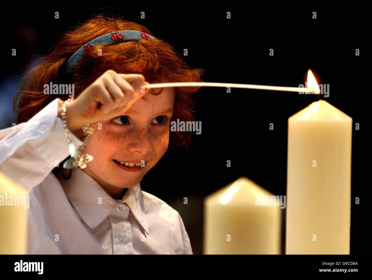 Lydia Hope zündet Kerzen um den Bombenanschlag der IRA Manchester erinnern, die heute vor zehn Jahren passiert ist. Stockfoto