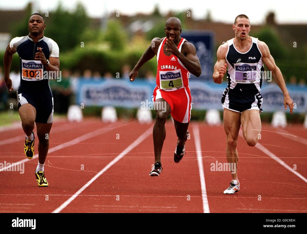 Leichtathletik - Aqua-Pura Bedford International - Straße Nach Sydney. L-R: Mark Lewis-Francis und Donovan Bailey werden von Ian Mackie (r), dem 100-m-Sieger der Männer, geschlagen Stockfoto