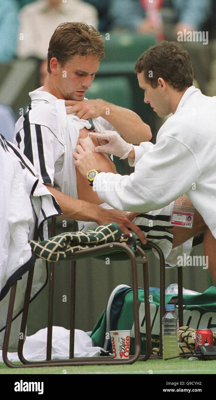 Tennis - Wimbledon Championships - Viertelfinale. Jan-Michael Gambill wird von einem Physio behandelt, nachdem er seine Brust verletzt hat Stockfoto