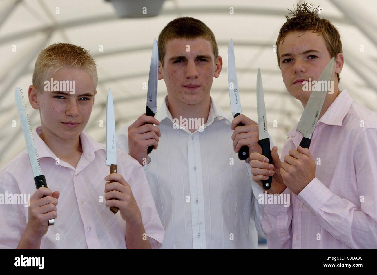 Richard Beckett, 14, von Milton Keynes (links) Stephen Lindsey, 14, und Ashleigh De Cruz, 15, (rechts), beide aus Aylesbury Val, Buckinghamshire, mit einer Auswahl an Messern, die von Kindern bei Testkäufen für das Trading Standards Institute gekauft wurden. Stockfoto