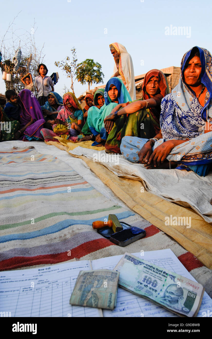 INDIEN, Madhya Pradesh, Mikrokredit, ländliche Frau Sparbank im Dorf, Analphabeten ungebildeten Adivasi Frauen unterzeichnen mit Daumen drucken für ihre Ersparnisse, Frauen Empowerment, Bhil Stamm, ST geplante Stamm Stockfoto