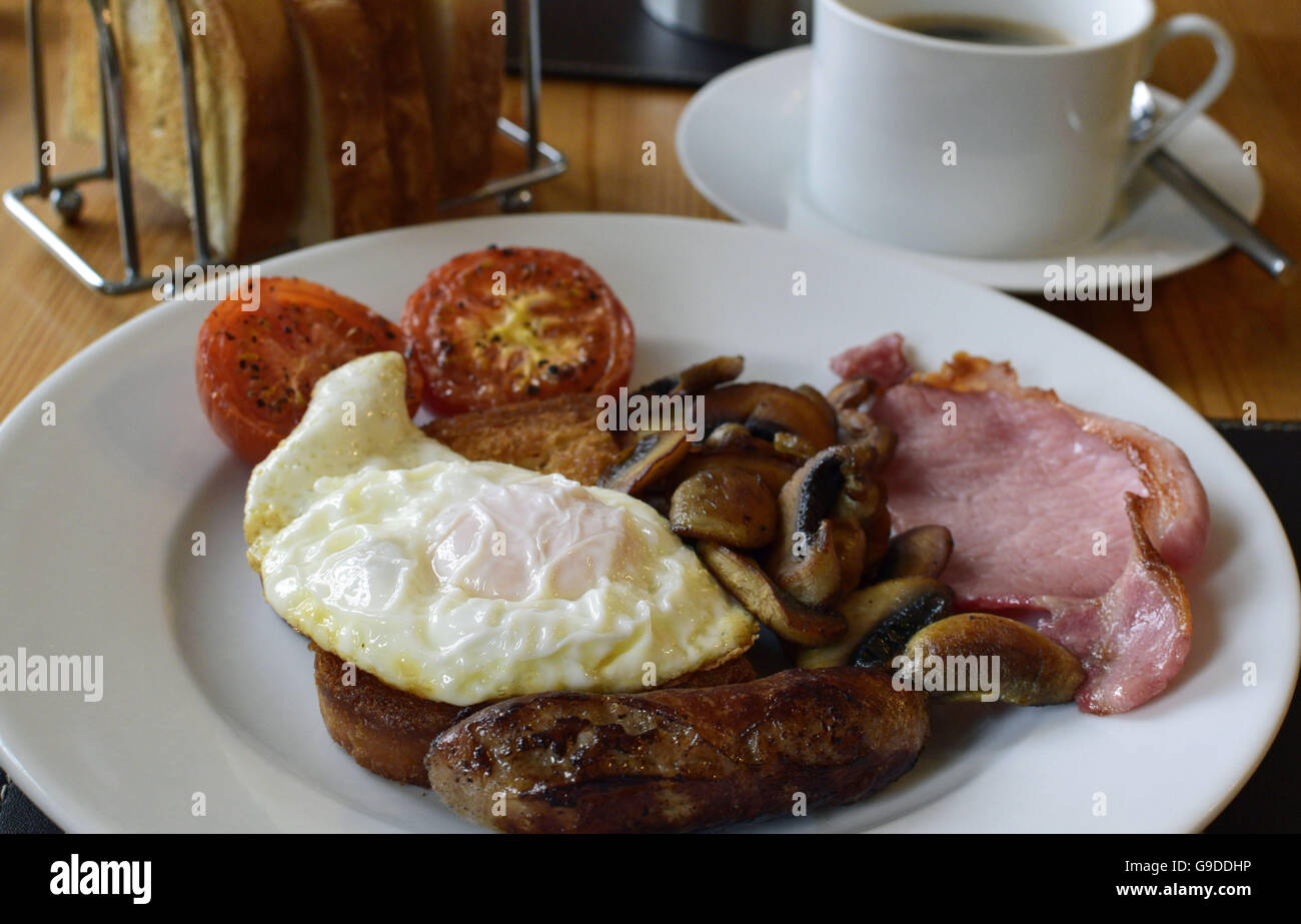 Komplettes warmes Frühstück mit Speck, Wurst, Pilzen und Tomaten Stockfoto