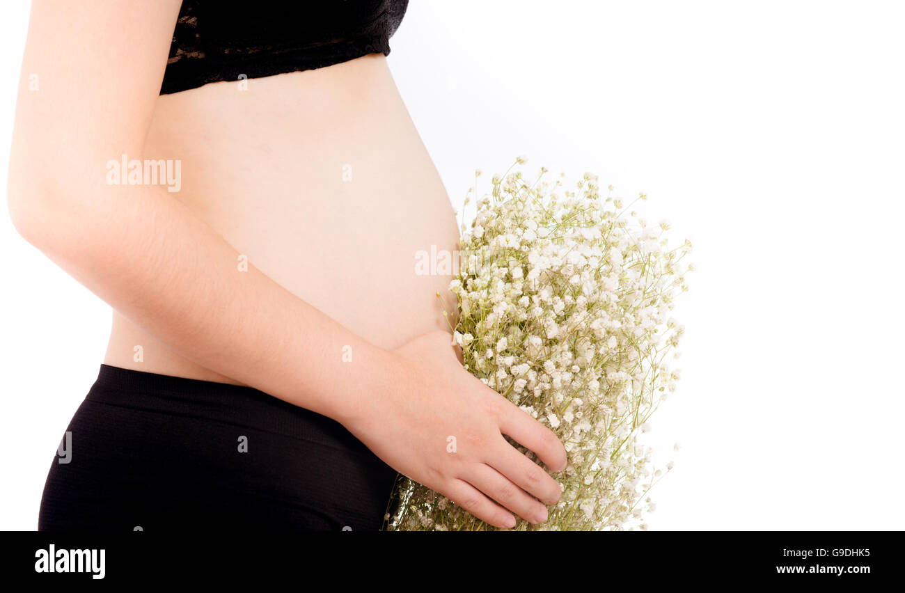 Schwangere Frau und Blumen auf weißem Hintergrund Stockfoto