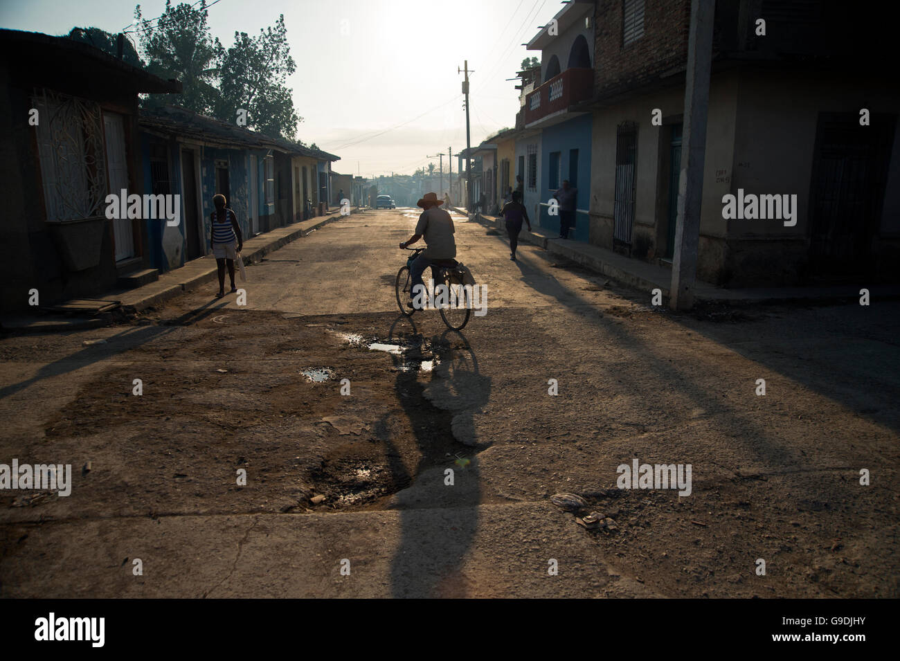 Ein Alter Mann einen Cowboy Hut Zyklen auf einer Straße in Trinidad Kuba als die Sonne untergeht Stockfoto
