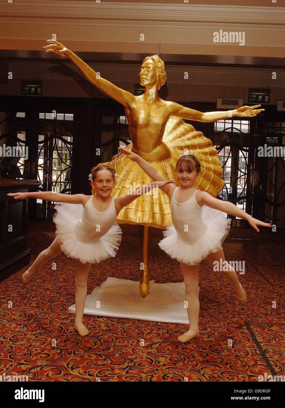 Ballerinas von Billy Elliot The Musical, zeigen die neue Statue der Anna Pavlova, oben auf das Victoria Palace Theatre in London schmücken wird. Bild Datum: Dienstag, 27. Juni. Stockfoto