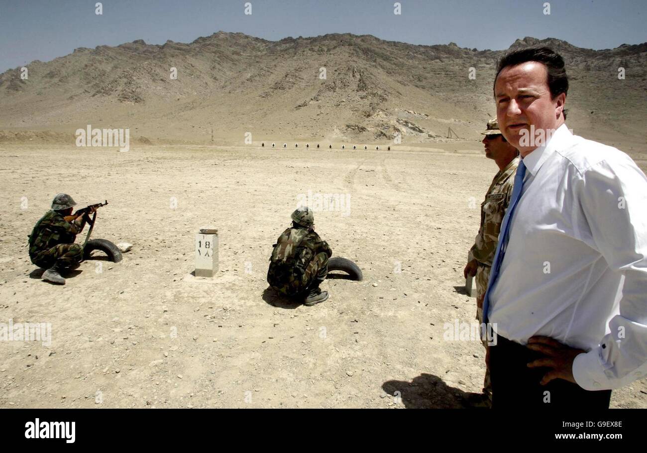 Der konservative Parteichef David Cameron und Danny O'Connor, Oberkommandant des Zuges an der afghanischen Offizierskandidaten-Schule, die von der britischen Armee in Kabul, Afghanistan, geleitet wird, beobachten am letzten Tag von Camerons dreitägiger Reise in das Land, wie Soldaten der afghanischen Nationalarmee auf dem Schießstand trainieren. Stockfoto