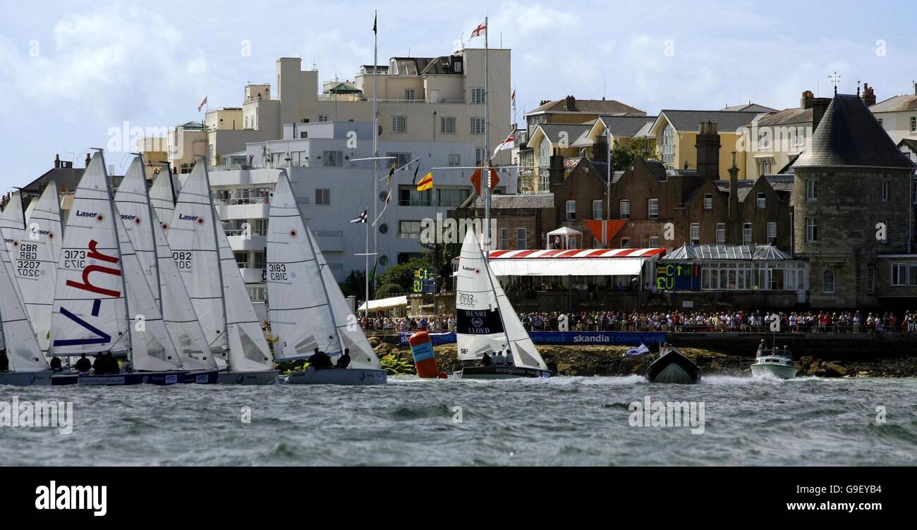 Eine der Laser SB3-Flotten schließt sich an die Startlinie vor dem Royal Yacht Squadron (rechts) an, als sie sich auf den Solent am zweiten Tag der Skandia Cowes Week-Regatta vor Cowes, Isle of Wight, vorbereiten. Stockfoto