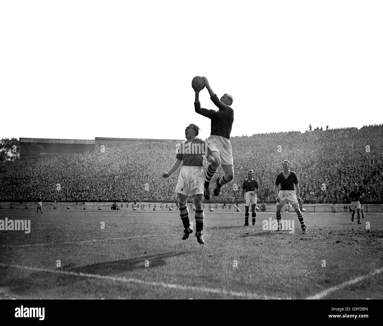 Manchester City Torwart Bert Trautmann (zweite l) fängt unter dem Druck von Chelsea's Eric Parsons (l) sicher ein Kreuz, beobachtet von Teamkollege Dave Ewing (r) und Chelsea's Roy Bentley (zweite r) Stockfoto