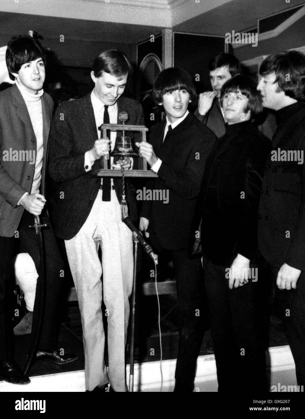Radio Caroline Discjockey Simon Dee (zweiter von links) übergibt den Beatles den Radio Caroline First Birthday 'Bell' Award in den Twickenham Film Studios. Von links nach rechts - Paul McCartney, George Harrison, Ringo Starr und John Lennon. Stockfoto