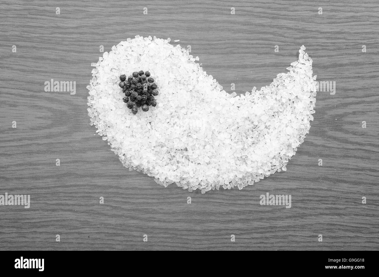 Salz als Yin auf hölzernen Hintergrund schwarz / weiß Stockfoto