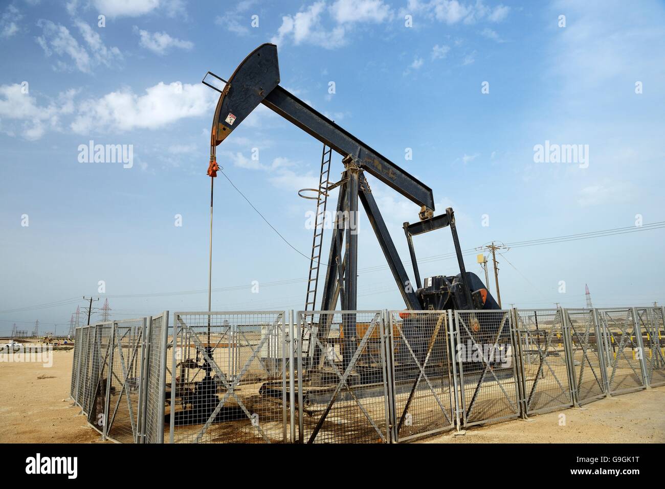 Bohrschwengels aka Öl Pferd, Esel, Öl Jack nickt wirft Strahl Pumpe Rohöl in der Wüste von Bahrain in Sakhir am Persischen Golf Stockfoto