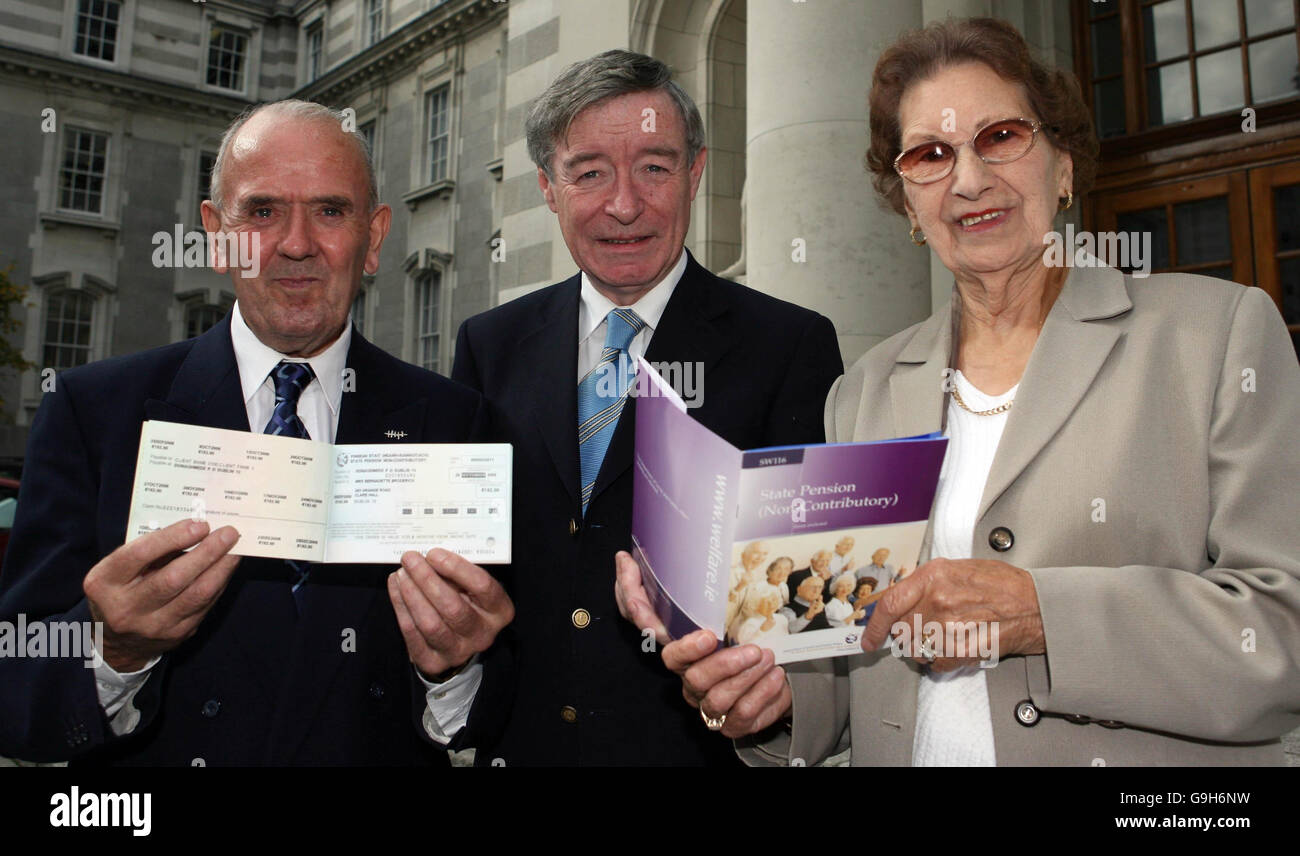 Sozialminister Seamus Brennan (Mitte) überreicht Eddie und Lilly Fitzgerald vom irischen seniorenrat auf einer Pressekonferenz in Dublin ihr neues modernisiertes Rentenbuch. Stockfoto