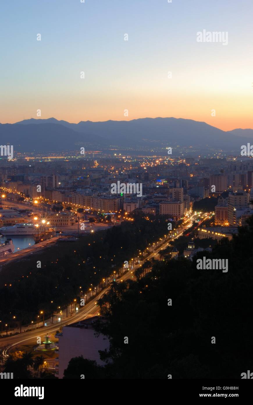 Erhöhten Blick auf Hafen und Promenade in der Abenddämmerung, Malaga, Costa Del Sol, Provinz Malaga, Andalusien, Spanien, Westeuropa. Stockfoto