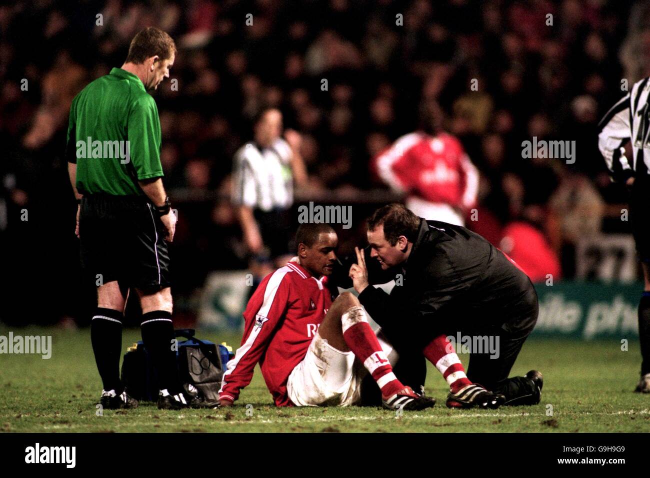 Charlton Athletic hält zwei Finger an Shaun Bartlett Um festzustellen, ob seine Vision nach einem Zusammenstoß in Ordnung ist Der Köpfe Stockfoto