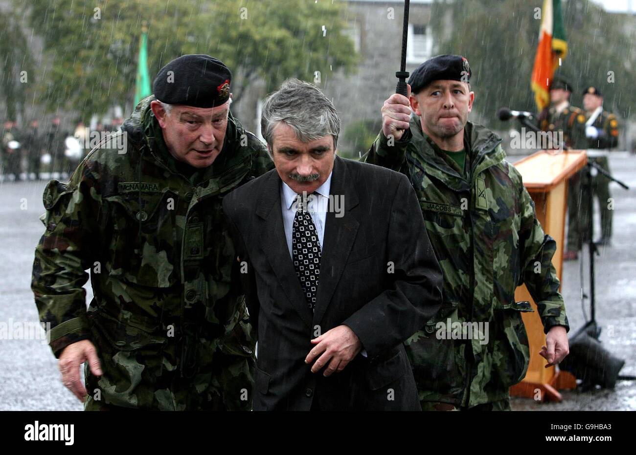 Verteidigungsminister Willie O'Dea läuft bei starken Regenfällen auf Deckung, als er die 33. Infanterie-Gruppe bei einer Parade in der Cathal Brugha Barracks, Dublin, in den Dienst der Kosovo Force (KFOR) übergeht. Stockfoto