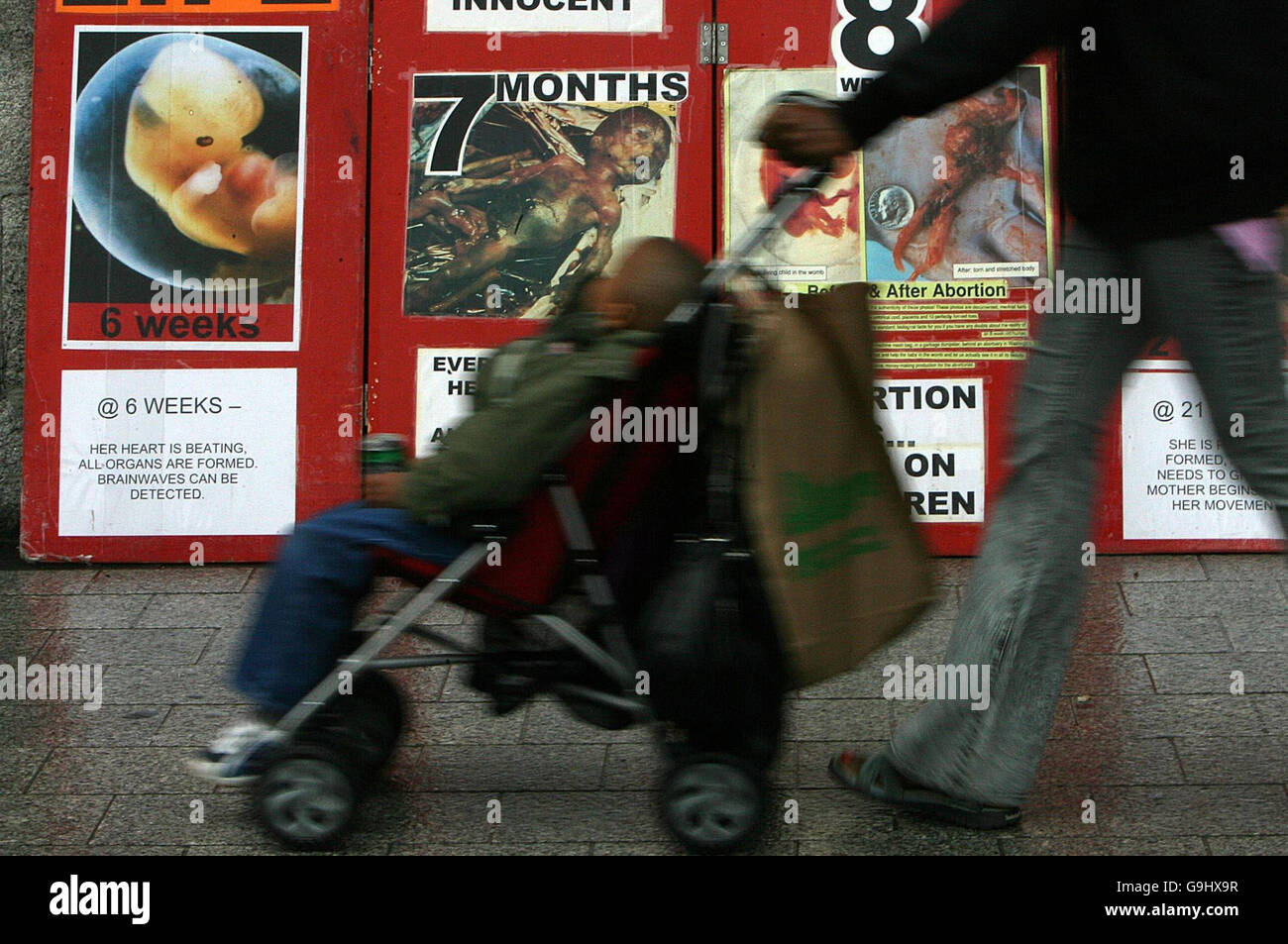 Anti-Abtreibungsplakat in Dublin. Eine Frau schiebt ihr Kind an einem Anti-Abtreibungsplakat in der O'Connell Street in Dublin vorbei. Stockfoto