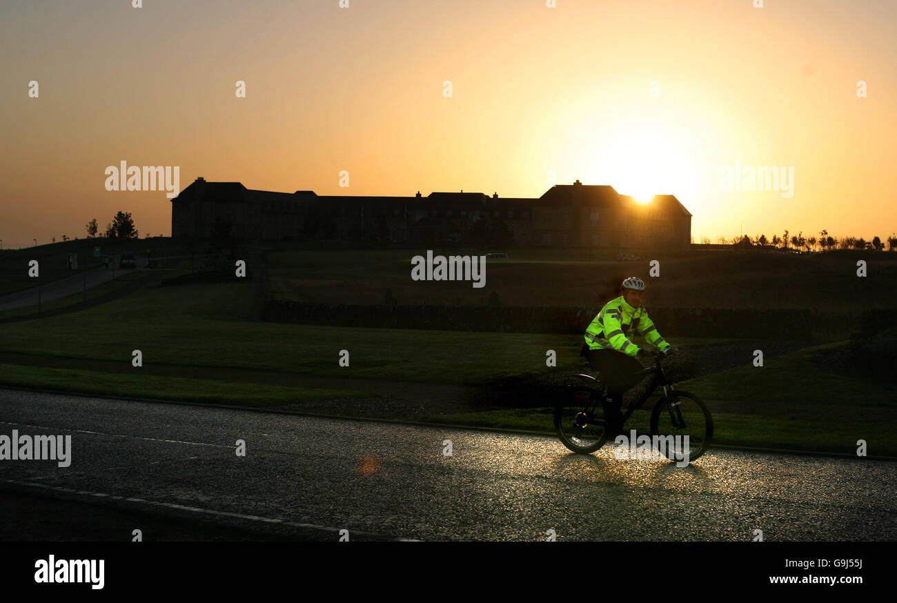 Ein Polizist kommt vorbei, als die Sonne über dem Fairmont Hotel in St. Andrews, Schottland, am dritten Tag der Gespräche über den Friedensprozess in Nordirland aufgeht. Stockfoto
