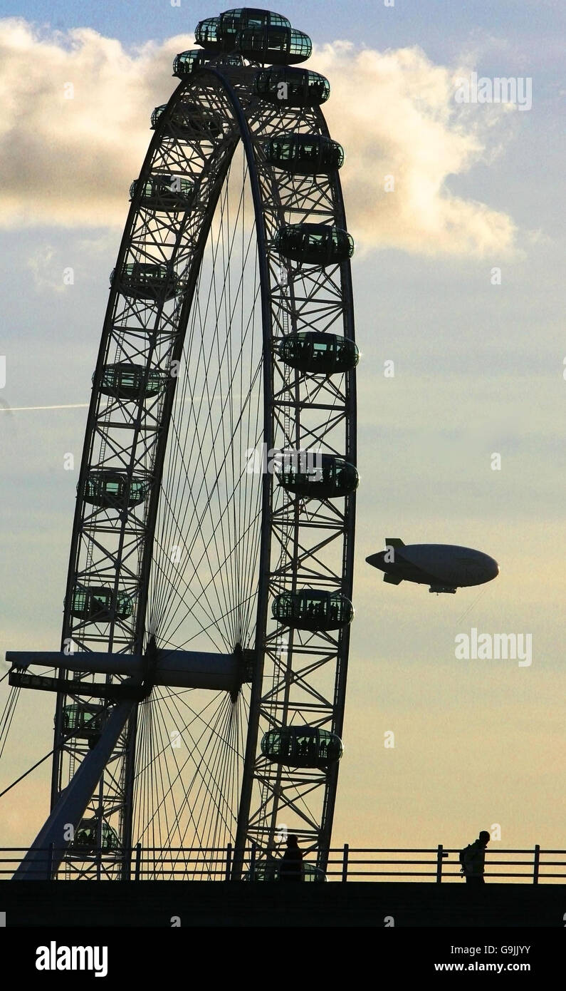 Der Spirit of Dubai, das größte kommerzielle Luftschiff der Welt, passiert das London Eye, während es über das Zentrum Londons fährt. Stockfoto