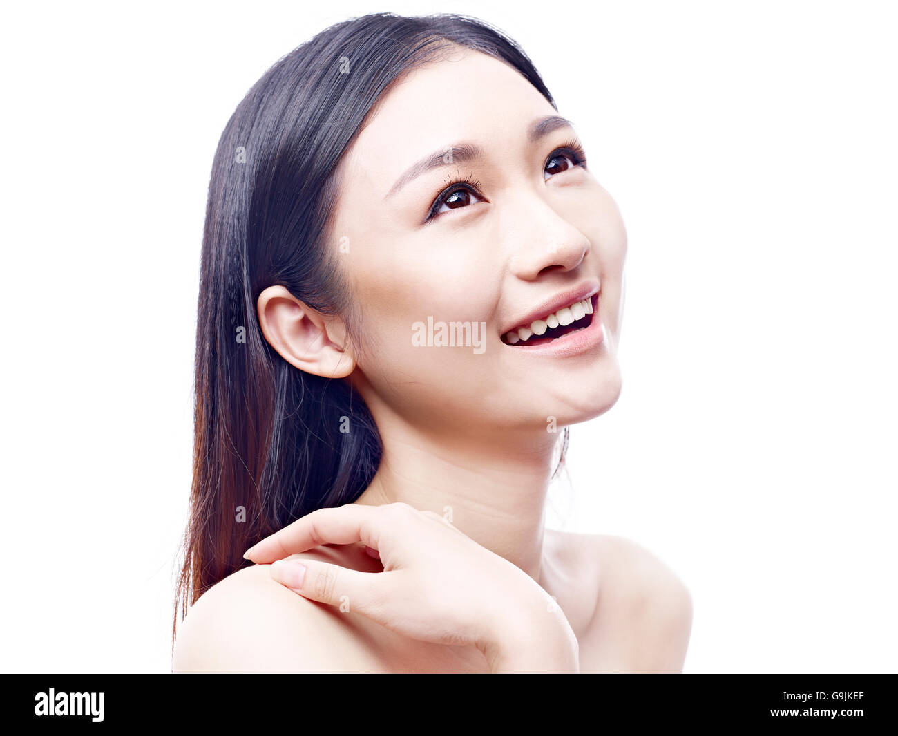 Studio-Porträt eines jungen und schönen asiatischen Modells, lange Haare, nachschlagen und lächelnd, isoliert auf weißem Hintergrund. Stockfoto