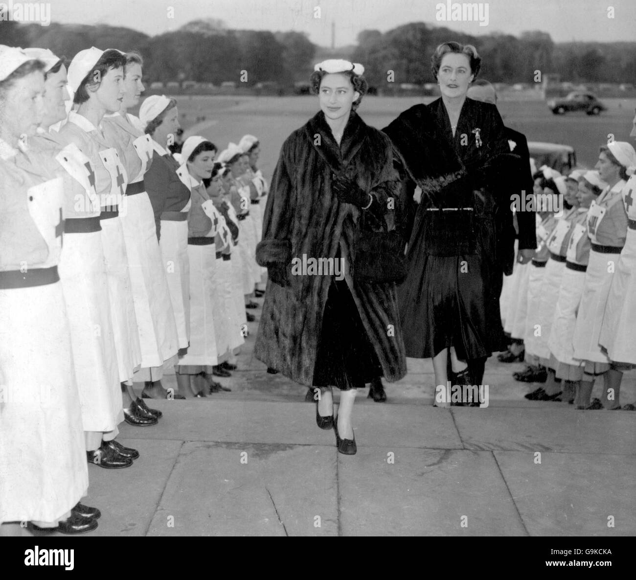 Krankenschwestern des Roten Kreuzes bilden eine Ehrenwache für Prinzessin Margaret, als sie zusammen mit der Herzogin von Marlborough den Blenheim Palace für eine Vorführung der Pariser Winterkollektion von Christian Dior, die zur Unterstützung des britischen Roten Kreuzes gehalten wird, betreten hat. Stockfoto