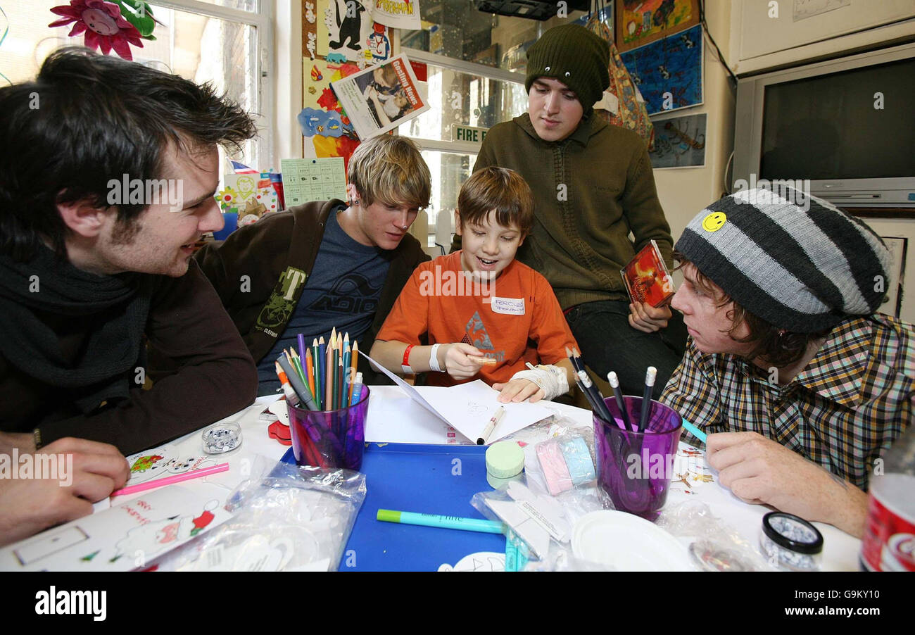 Mitglieder des McFly (von links nach rechts) Harry Judd, Dougie Poynter, Tom Fletcher und Danny Jones Hilfe Fergus Hunt, Alter 11 von Chelmsford in Essex, entwerfen eine Weihnachtskarte im Great Ormond Street Children Hospital im Zentrum von London. Stockfoto