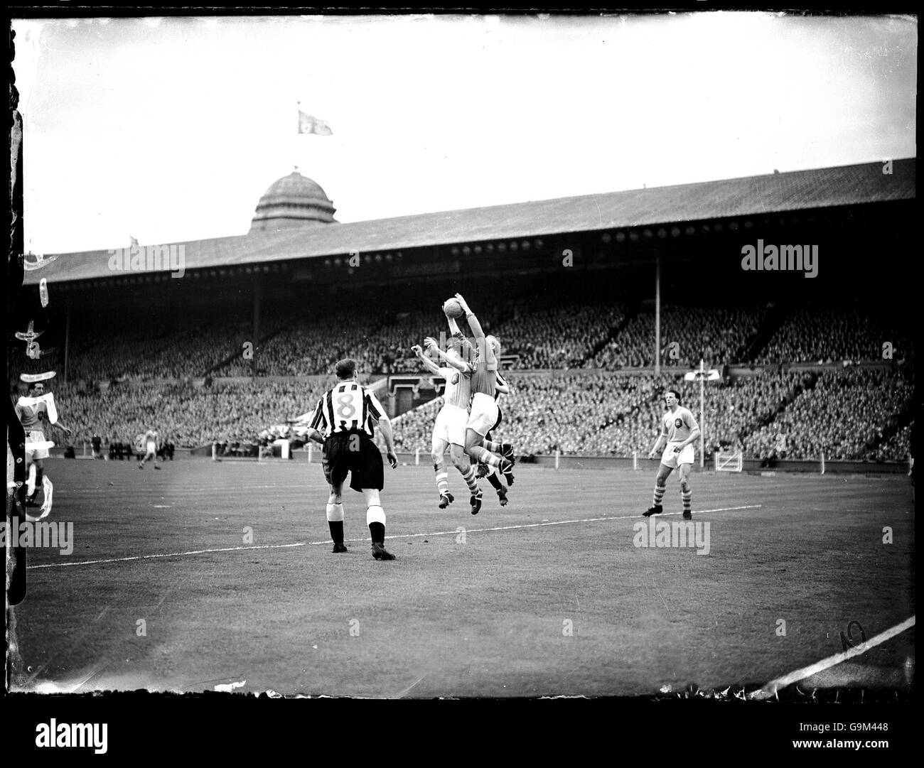 Fußball - FA Cup Finale - Newcastle United gegen Manchester City - Wembley Stadium. Jackie Milburn (l) von Newcastle United sieht zu, wie Manchester City-Torhüter Bert Trautmann (zweite R) ein Kreuz beansprucht Stockfoto