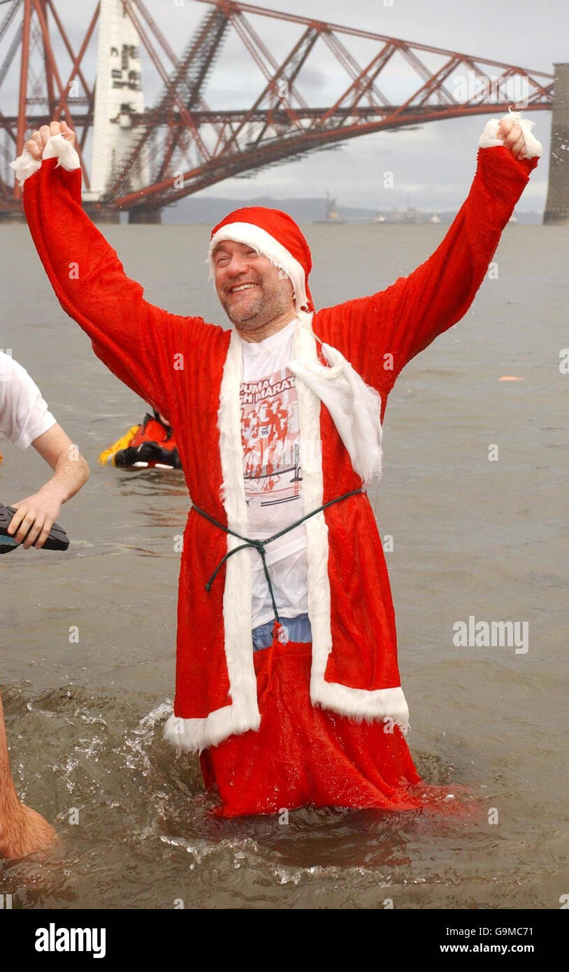 Der Weihnachtsmann feiert das Ende von Weihnachten, indem er das eisige Wasser des Firth of Forth für das 21. Loony Dook Wohltätigkeitsschwimmen in Edinburgh trotzt. Stockfoto