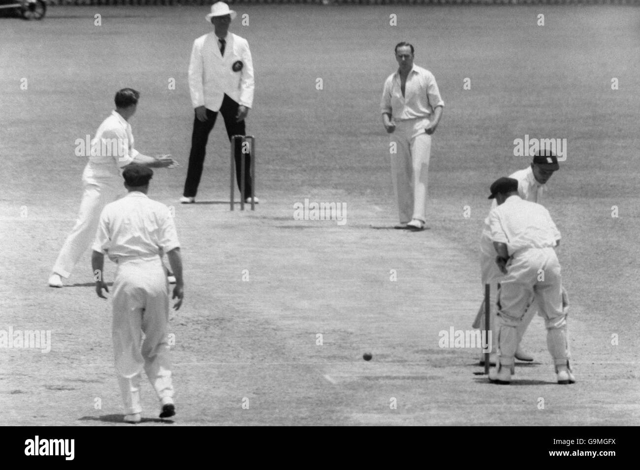 Cricket - die Asche - erster Test - Australien gegen England - die Gabba - Vierter Tag. Der englische Frank Tyson (r, halb versteckt) dreht sich um zu sehen, dass er vom australischen Ian Johnson (dritte r) sauber gebumt wurde. Stockfoto