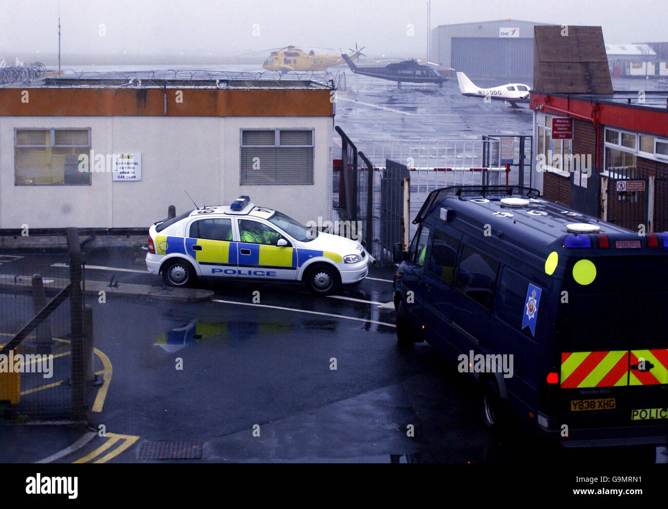 Die Polizei am Offshore-Luftterminal am Blackpool Airport, mit einem RAF Sea King Hubschrauber im Hintergrund, nach der gestrigen Bergung von sechs Leichen aus der Irischen See nach einem Hubschrauberabsturz vor Morecambe Bay. Stockfoto