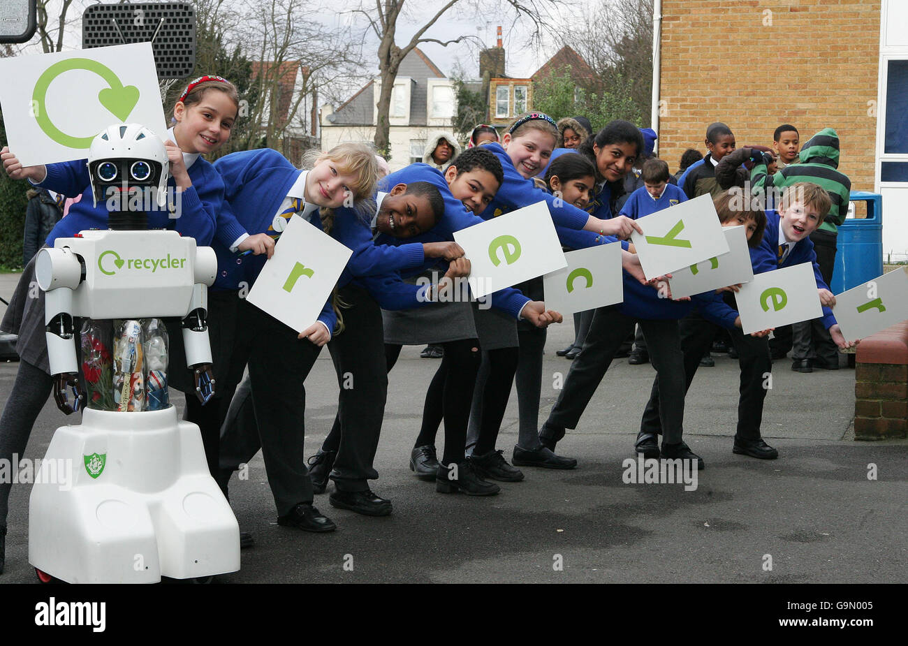 Kinder der St Leonard's Primary School in Streatham, im Süden Londons, werden von 'Recycler', dem hochmodernen Rapping-Roboter, begleitet, der in diesem Jahr an Grundschulen Touren wird. Stockfoto