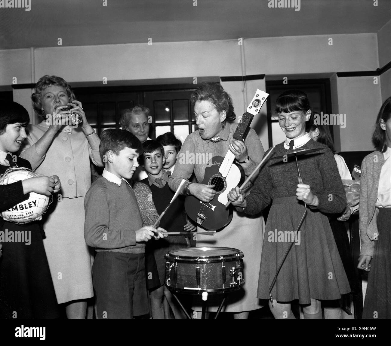 Dame Gracie Fields während eines Liedes mit Jugendlichen im Kinderheim und Waisenhaus, das sie vor 50 Jahren in Peacehaven gegründet hat. Stockfoto Dame Gracie Fields während eines Liedes mit Jugendlichen im Kinderheim und Waisenhaus, das sie vor 50 Jahren in Peacehaven gegründet hat. Stockfoto