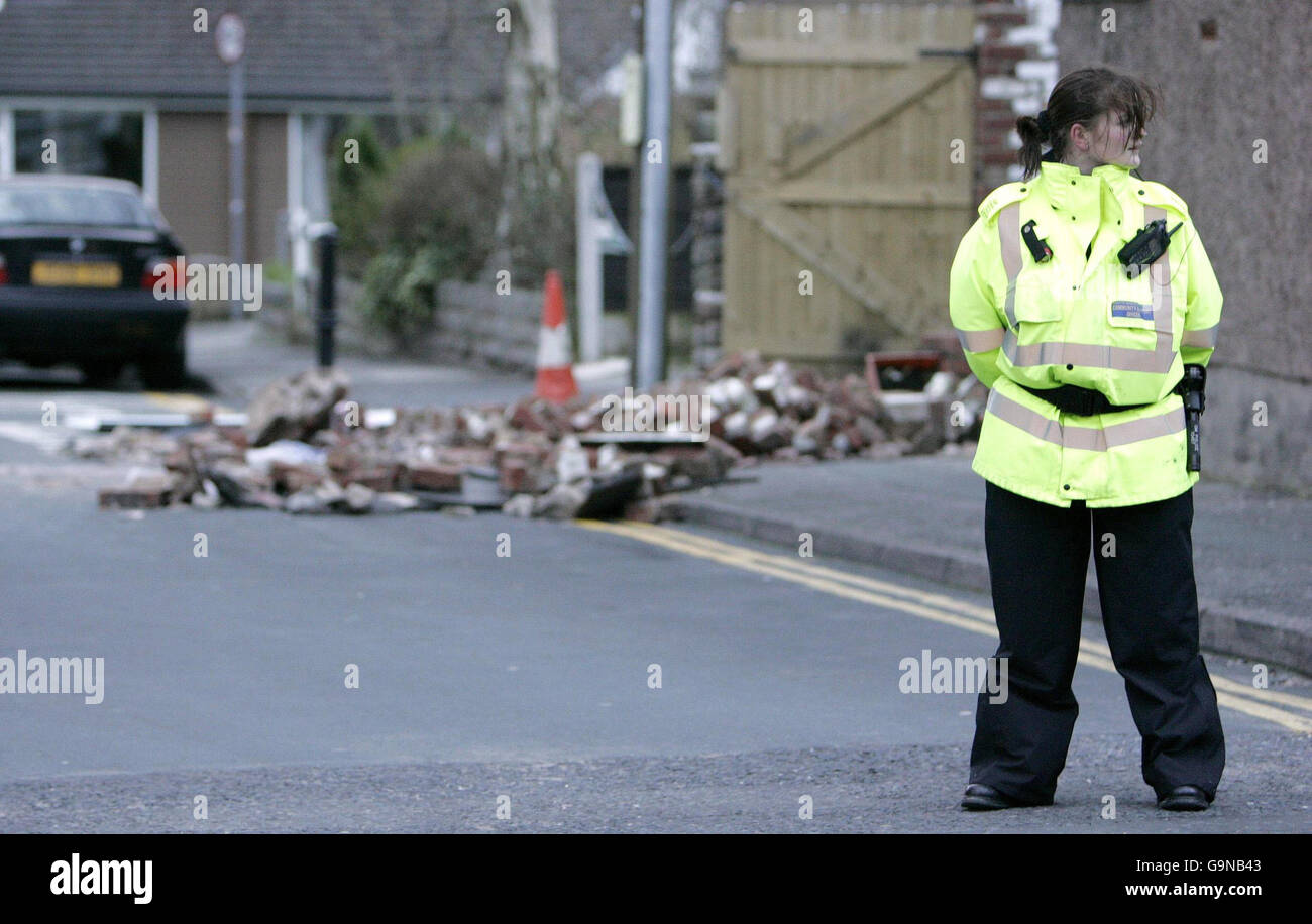 Ein Community Support Officer steht auf Fern Close, Stockport, nach dem Einsturz einer Mauer. Stockfoto