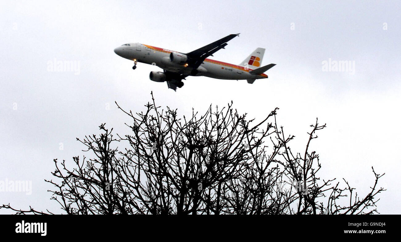 Ein Flugzeug fliegt über einen Wald in der Nähe des Flughafens Heathrow an dem Tag, an dem die Fluggaststeuer kontrovers verdoppelt wurde. Stockfoto
