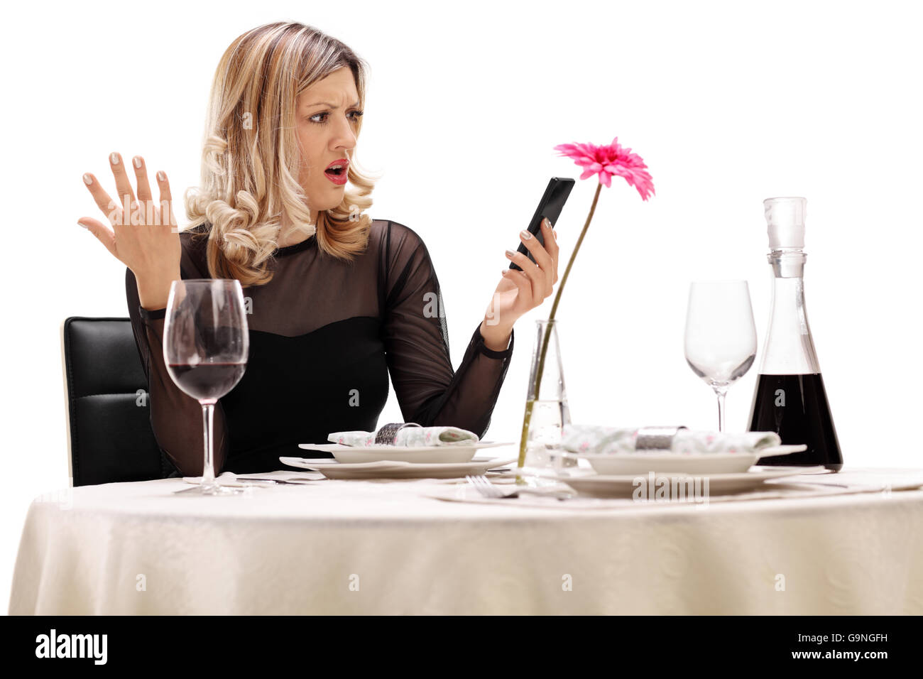Unzufrieden Frau sitzt an einem Tisch im Restaurant und Lesen einer Nachricht auf ihr Handy isoliert auf weißem Hintergrund Stockfoto
