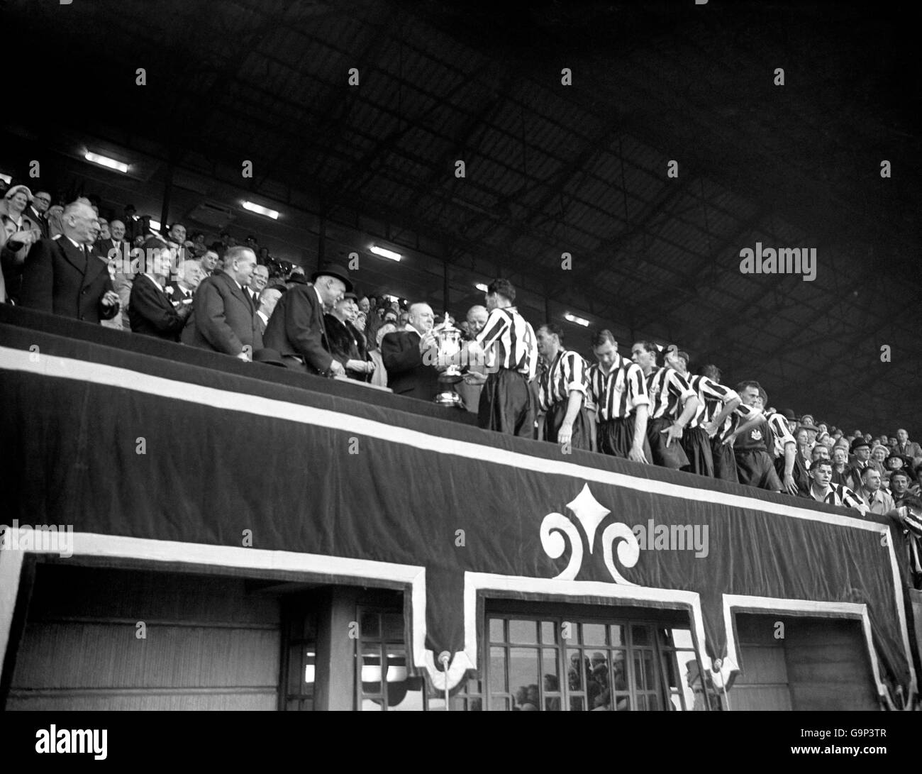 Fußball - FA Cup - Finale - Arsenal gegen Newcastle United - Wembley Stadium. Premierminister Winston Churchill überreicht den FA Cup an den Kapitän der Newcastle United, Joe Harvey Stockfoto