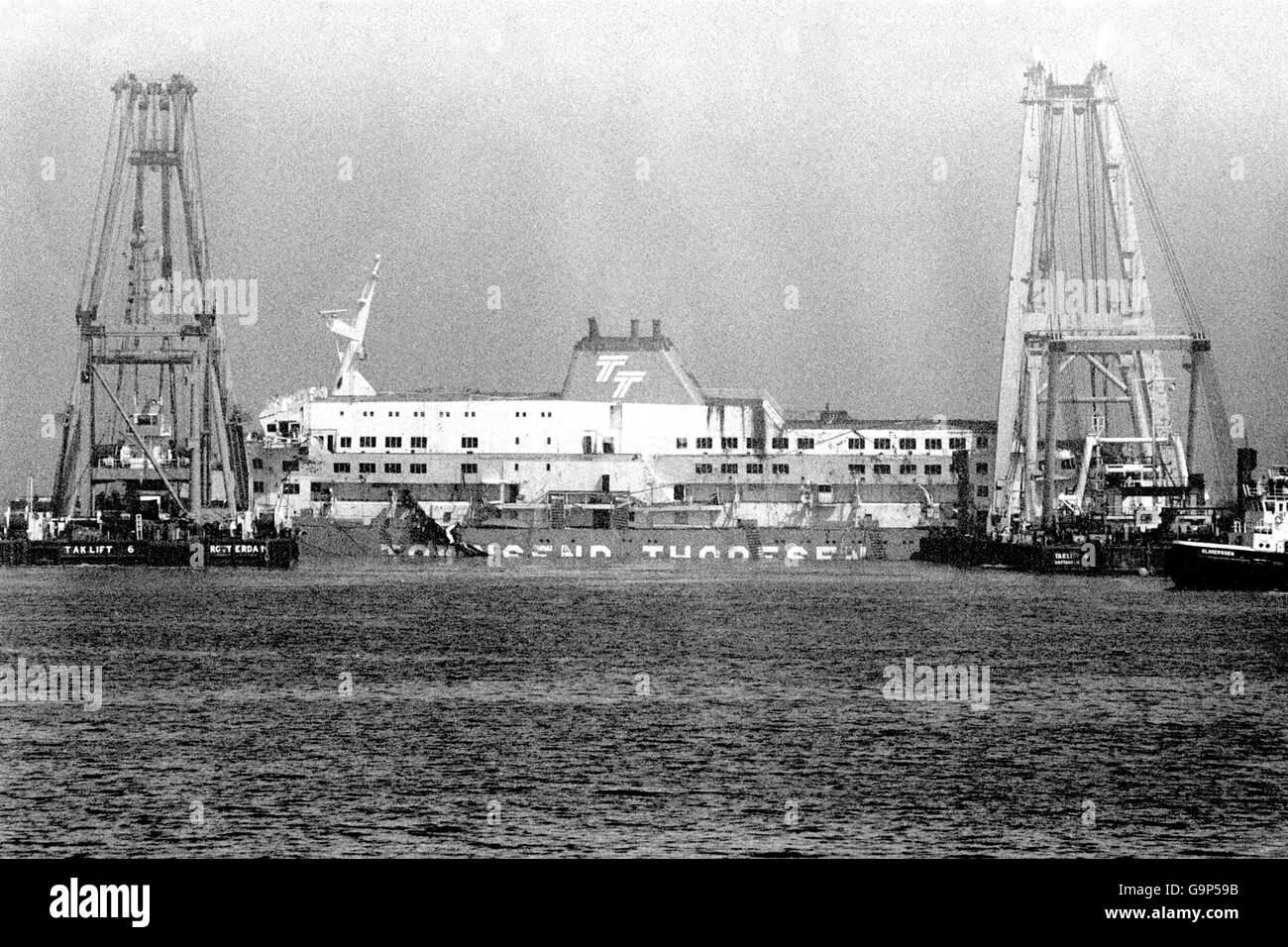 Der Herald of Free Enterpirse wird von zwei riesigen Lastkräne in den Hafen gezogen. Mehr als sieben Wochen nach der Fährkatastrophe kehrt das Schiff in den Hafen von Zeebrugge zurück. Stockfoto