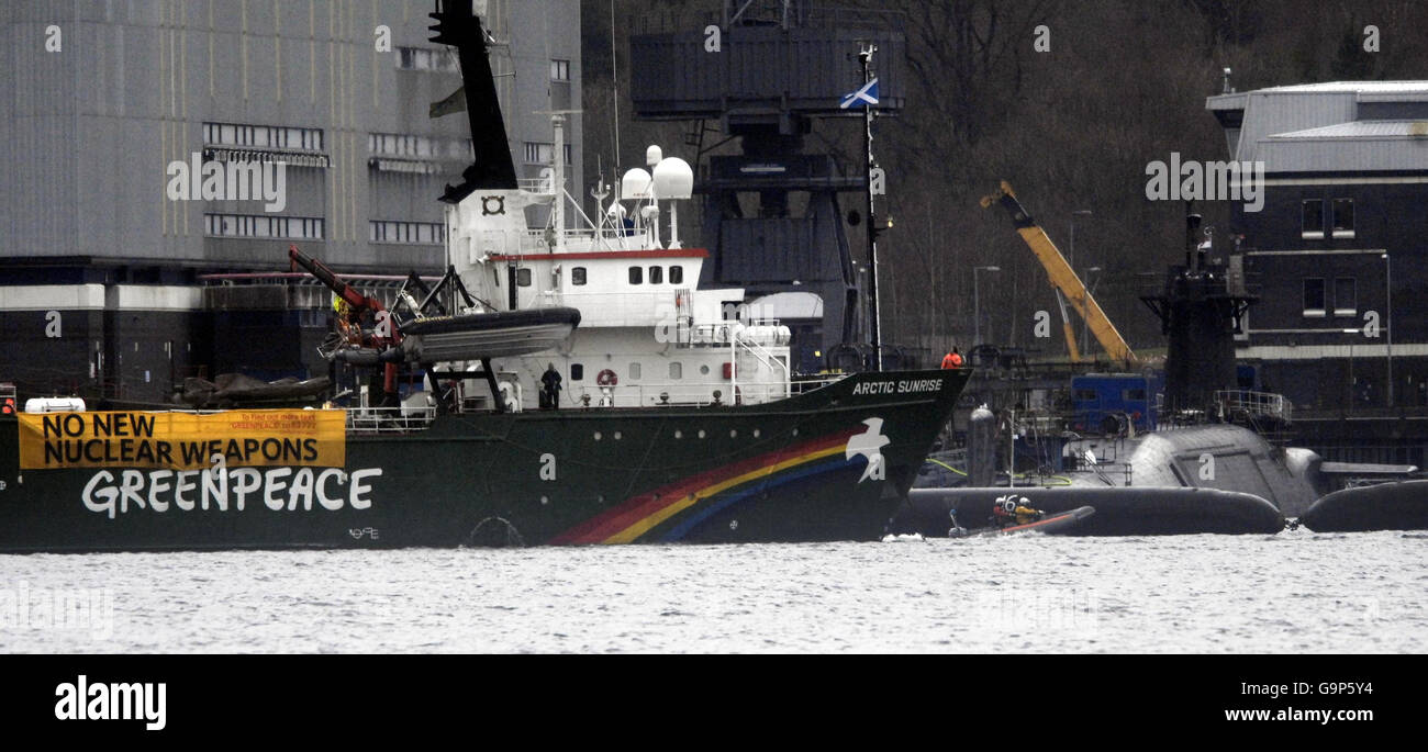 Das Greenpeace-Schiff Arctic Sunrise liegt neben dem Atom-U-Boot HMS Vigilant, das an der Faslane Naval Base in Schottland angedockt ist. Stockfoto