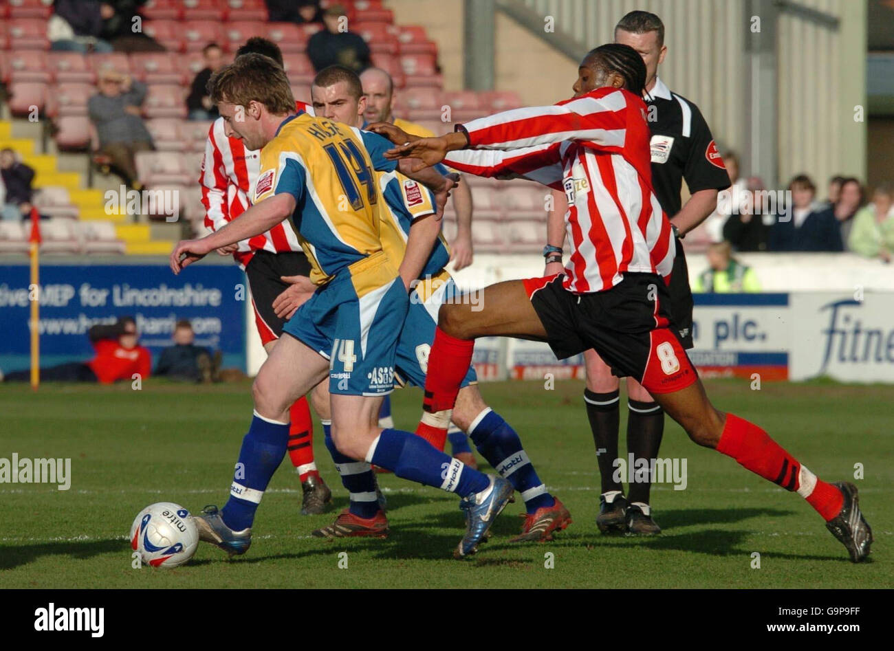 Lincoln's Dany N'Guessan (rechts) räumt einen Freistoß mit einem Rückstoß auf Mansfields Brian Hodge während des Coca-Cola Football League Two Spiels in Sincil Bank, Lincoln. Stockfoto