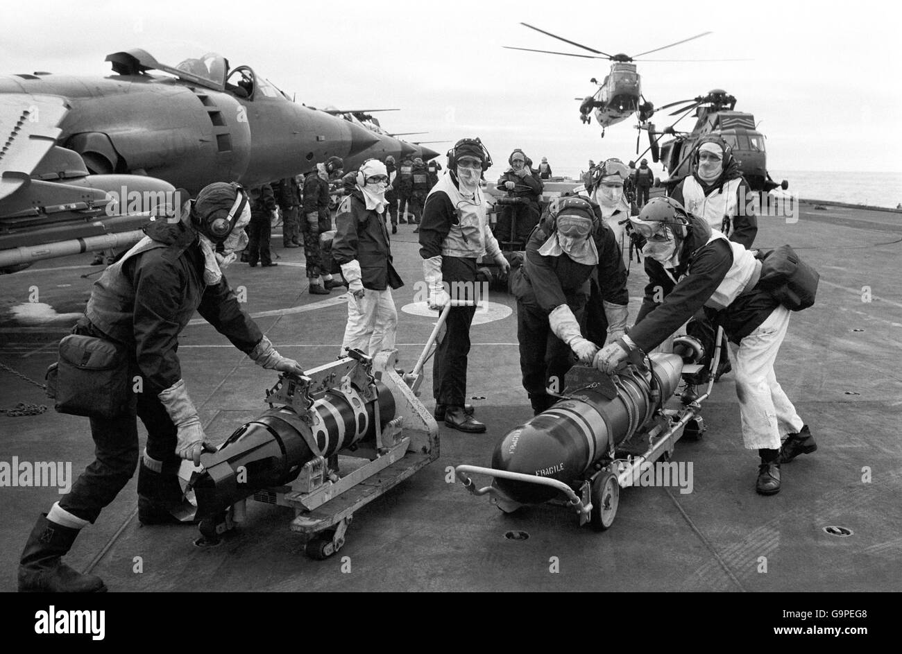 Waffenträger bewegen Torpedos über das Flugdeck des Trägers HMS Hermes. Stockfoto