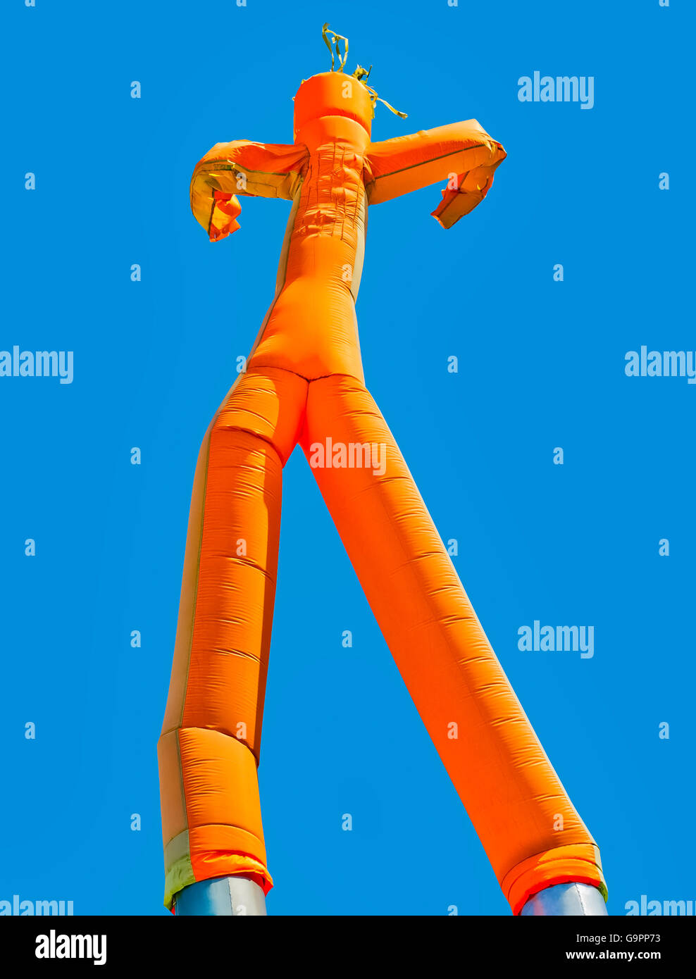 Orange aufblasbare Mann auf blauen Himmelshintergrund Stockfoto