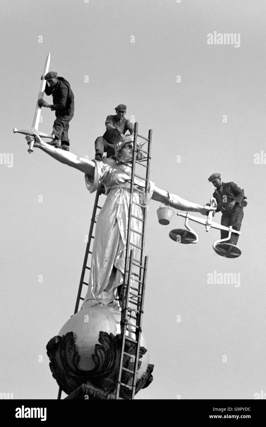 Männer, die während der Operation, die Statue der Gerechtigkeit über dem Old Bailey zu reinigen, in prekären Positionen arbeiten Stockfoto