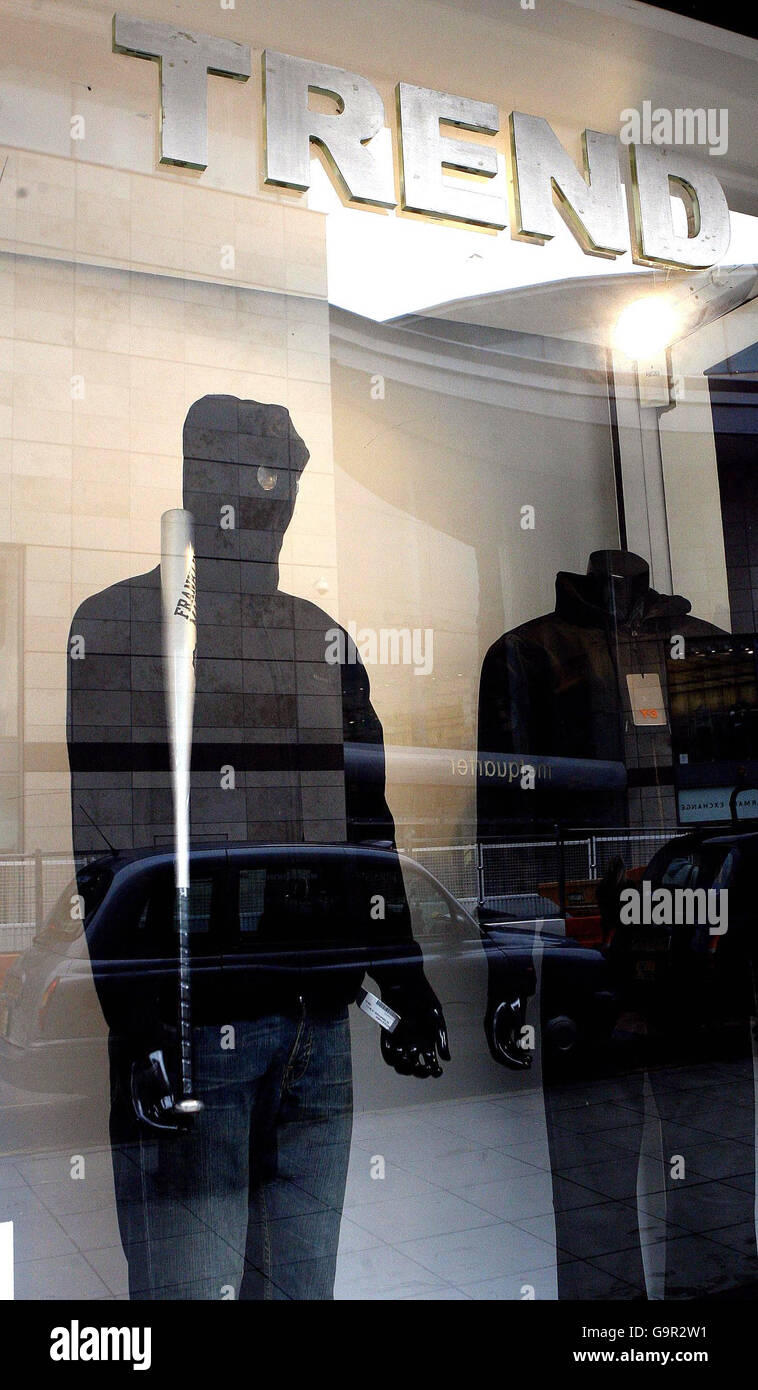 Bekleidungsgeschäft verteidigt bewaffneten Hoodie Schaufenster Stockfoto