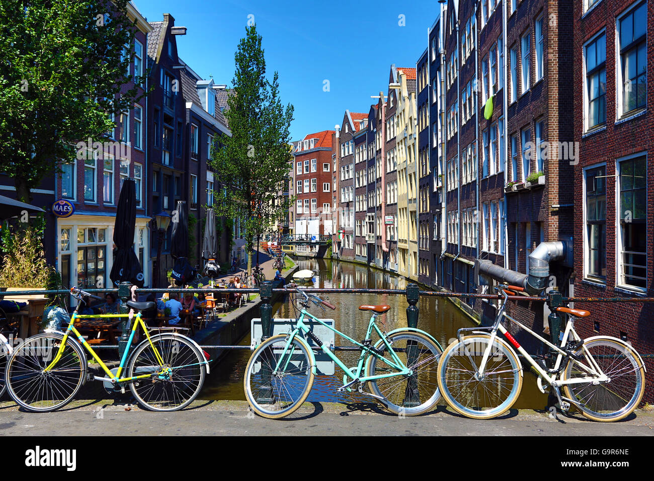 Fahrräder auf einer Brücke auf den Oudezijds Achterburgwal Kanal und Häuser in Amsterdam, Holland Stockfoto