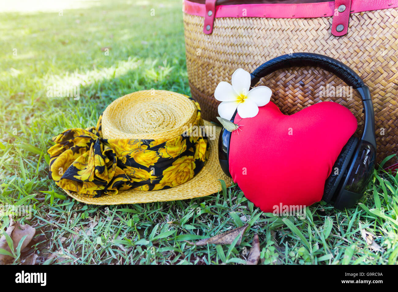 Rotes Herz hören Sie Musik über Kopfhörer und Sommer Hut und Tasche im Hintergrund mit entspannen, frische Sommer feeling, süß und lieblich Stockfoto