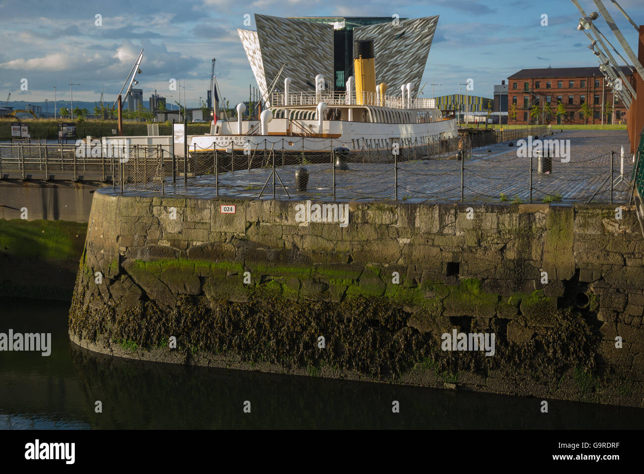 Die Titanic Belfast Besucherzentrum Erfahrung mit SS Nomadic im Vordergrund Stockfoto