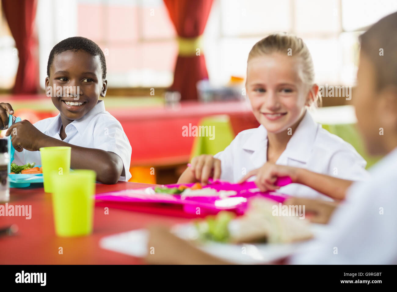 Kinder während der Pausen in der Cafeteria der Schule zu Mittag Stockfoto