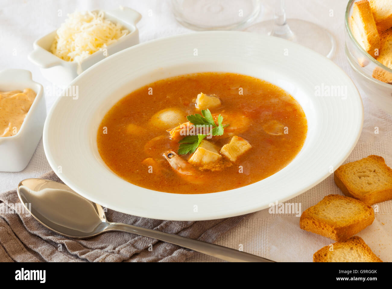 Ein Teller mit französischen Fisch und Meeresfrüchte Suppe, serviert mit Toast, Rouille-Sauce und geriebenem Käse Stockfoto